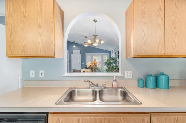 kitchen with lofted ceiling, light brown cabinets, light countertops, a chandelier, and a sink