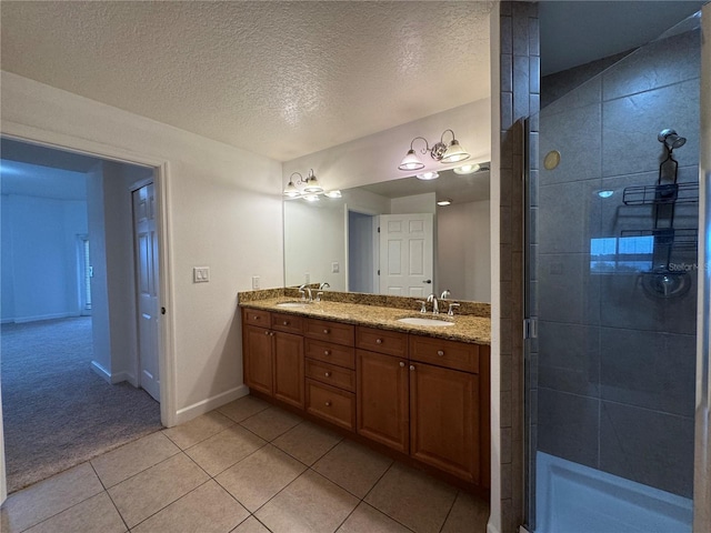 6336 Buford St Unit 307, Orlando, FL 32835 - bathroom with tile patterned flooring, double vanity, baseboards, tiled shower, and a sink