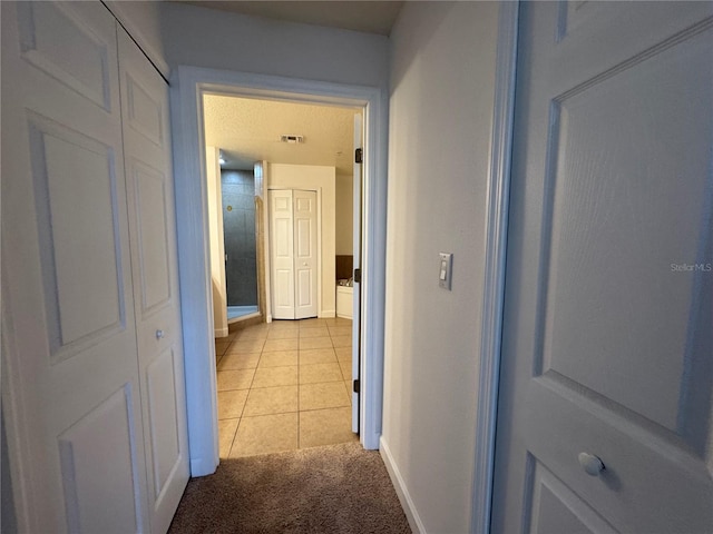 6336 Buford St Unit 307, Orlando, FL 32835 - hallway featuring light tile patterned floors, baseboards, light carpet, and visible vents