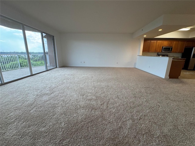 6336 Buford St Unit 307, Orlando, FL 32835 - unfurnished living room featuring recessed lighting, baseboards, and light carpet