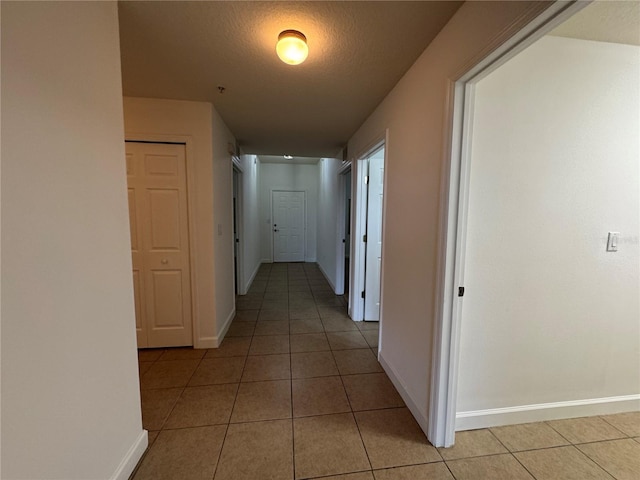 6336 Buford St Unit 307, Orlando, FL 32835 - hallway with a textured ceiling, baseboards, and light tile patterned floors