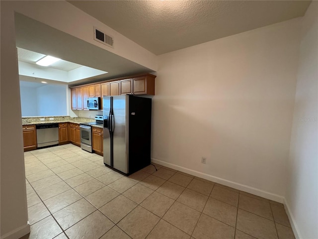 6336 Buford St Unit 307, Orlando, FL 32835 - kitchen with visible vents, baseboards, light tile patterned floors, and stainless steel appliances