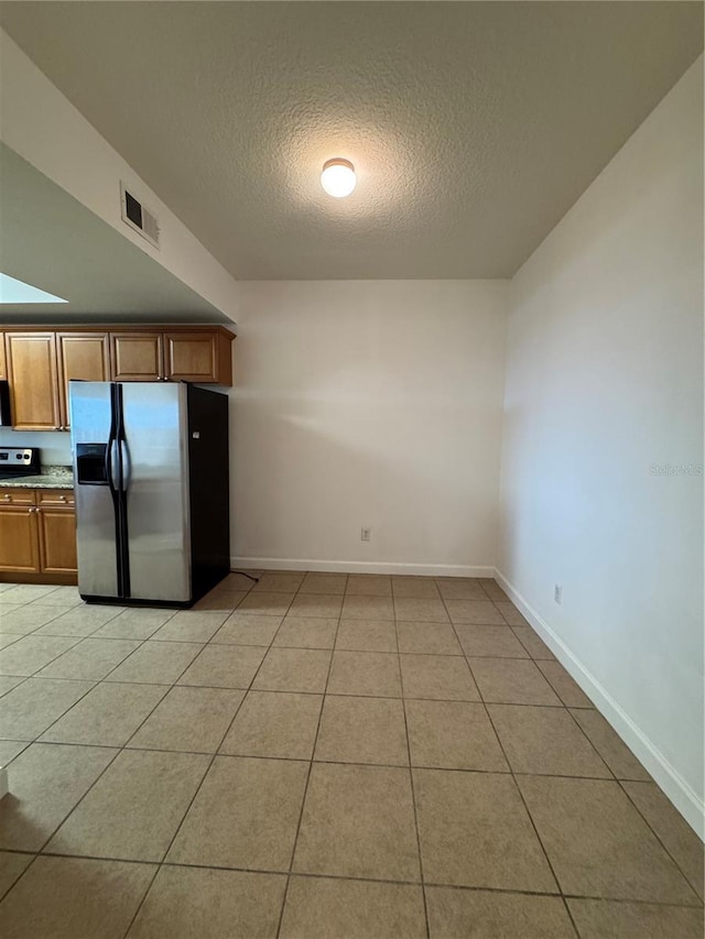 6336 Buford St Unit 307, Orlando, FL 32835 - kitchen featuring visible vents, baseboards, a textured ceiling, brown cabinets, and appliances with stainless steel finishes
