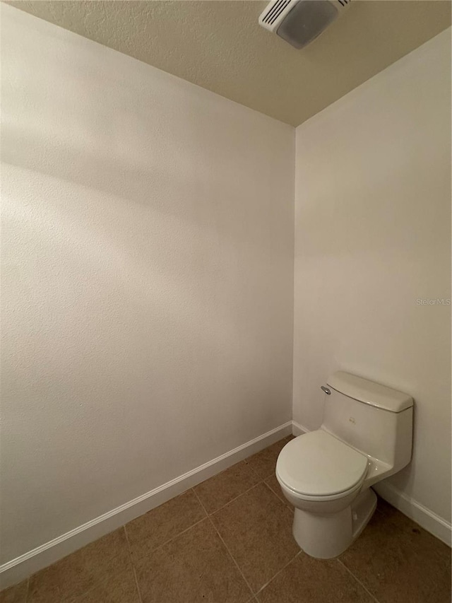 6336 Buford St Unit 307, Orlando, FL 32835 - bathroom featuring baseboards, a textured ceiling, tile patterned flooring, and toilet
