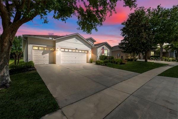 5839 Tarleton Way, Mount Dora, FL 32757 - ranch-style home featuring an attached garage, driveway, a yard, and stucco siding
