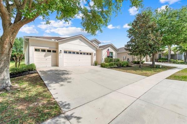 5839 Tarleton Way, Mount Dora, FL 32757 - ranch-style house with a garage, driveway, and stucco siding