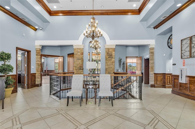 5839 Tarleton Way, Mount Dora, FL 32757 - dining room with a high ceiling, a chandelier, a wainscoted wall, decorative columns, and crown molding