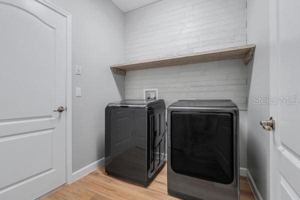 5839 Tarleton Way, Mount Dora, FL 32757 - laundry room featuring independent washer and dryer, light wood-style floors, and baseboards