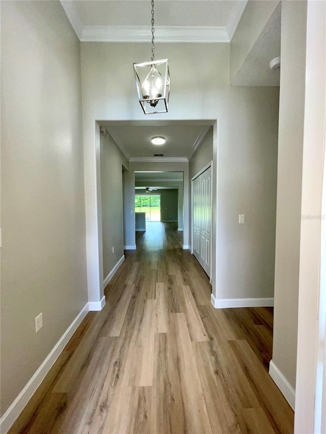 5839 Tarleton Way, Mount Dora, FL 32757 - corridor featuring wood finished floors, ornamental molding, baseboards, and a chandelier