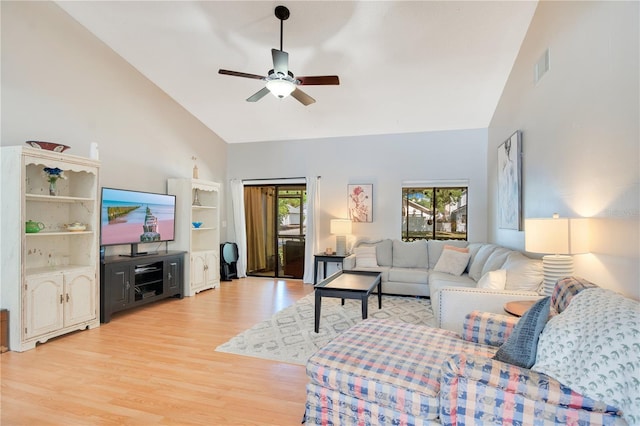 living area featuring high vaulted ceiling, a ceiling fan, light wood finished floors, and visible vents