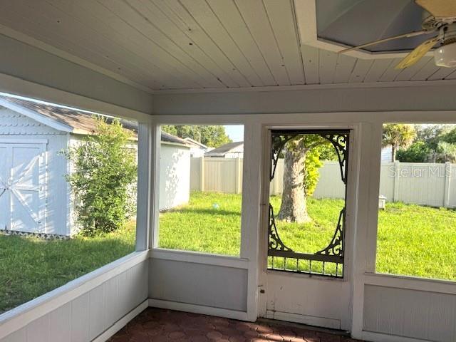 unfurnished sunroom with a healthy amount of sunlight and a ceiling fan