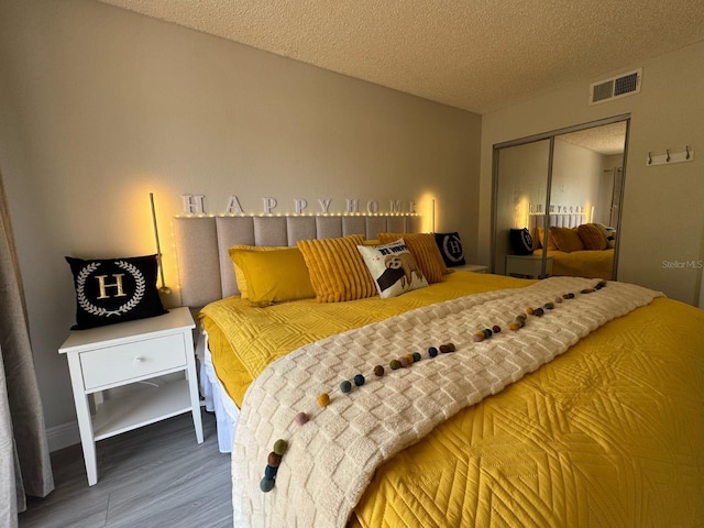 6403 Parc Corniche Dr Unit 4308, Orlando, FL 32821 - bedroom featuring a textured ceiling, a closet, wood finished floors, and visible vents