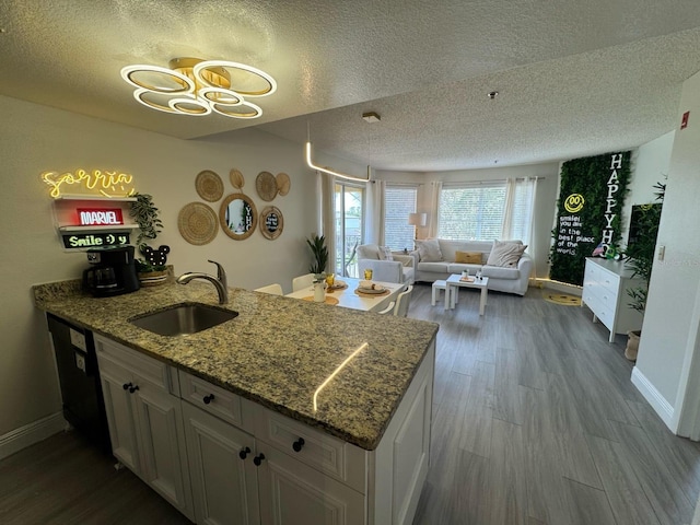 6403 Parc Corniche Dr Unit 4308, Orlando, FL 32821 - kitchen with a peninsula, a textured ceiling, dark wood finished floors, and a sink