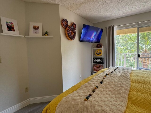 6403 Parc Corniche Dr Unit 4308, Orlando, FL 32821 - bedroom featuring a textured ceiling, baseboards, and wood finished floors