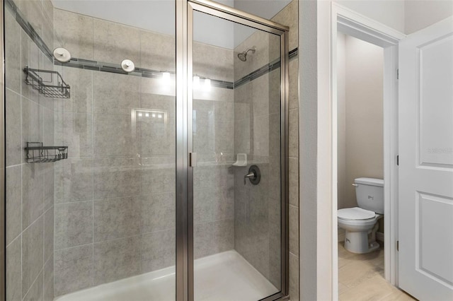 bathroom featuring toilet and a stall shower