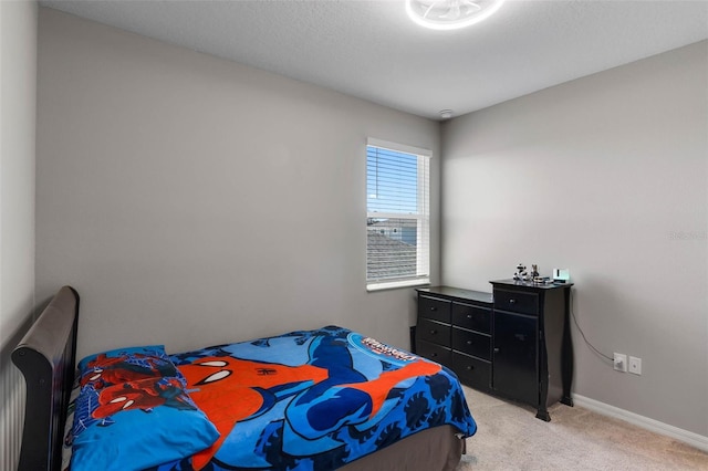 bedroom featuring baseboards and light carpet
