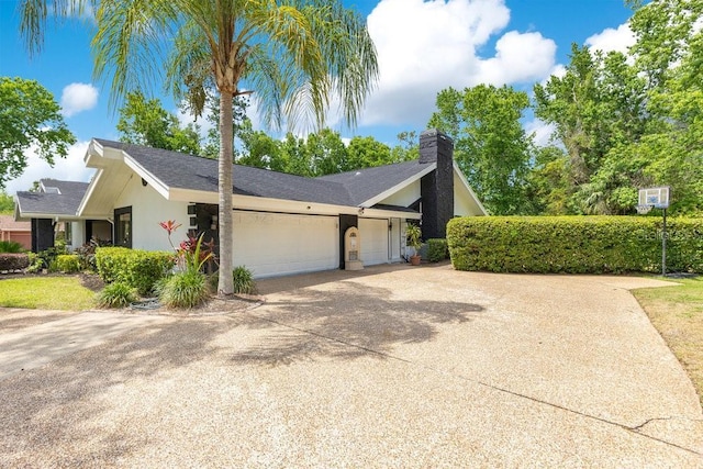 2108 Silver Leaf Ct, Longwood, FL 32779 - view of side of home with roof with shingles, an attached garage, concrete driveway, and a chimney