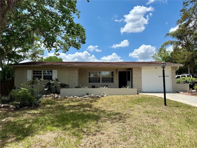ranch-style home with driveway, a front lawn, an attached garage, and stone siding