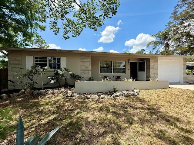 single story home featuring driveway, stucco siding, stone siding, and a garage