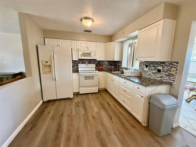 kitchen featuring white cabinetry, tasteful backsplash, white appliances, and light wood-style floors