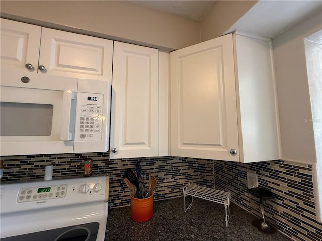 interior details featuring stove, white cabinets, white microwave, and tasteful backsplash