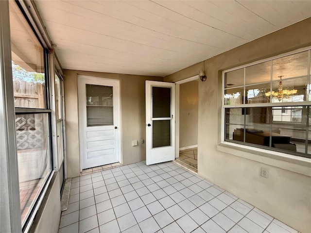 unfurnished sunroom with a notable chandelier
