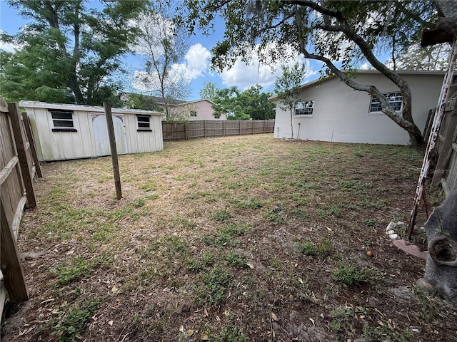 view of yard with an outdoor structure, a storage shed, and a fenced backyard