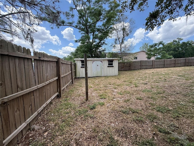 view of yard with an outbuilding, a shed, and a fenced backyard
