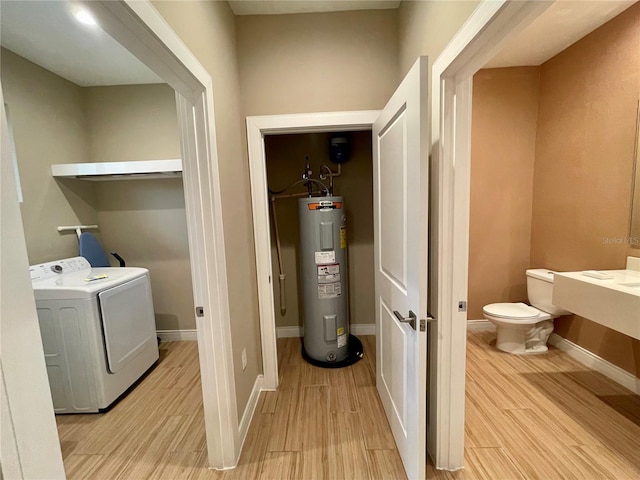 laundry area featuring electric water heater, light wood-style flooring, laundry area, and washing machine and dryer