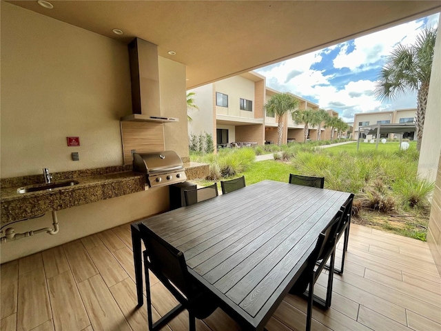 deck with exterior kitchen, outdoor dining area, a sink, and grilling area