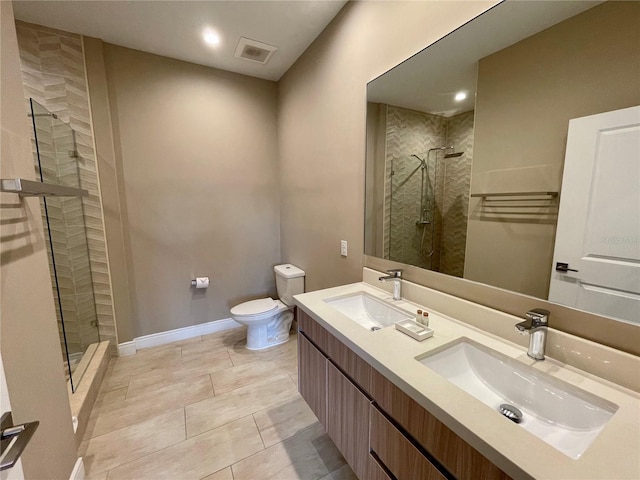 full bathroom featuring a stall shower, toilet, and a sink