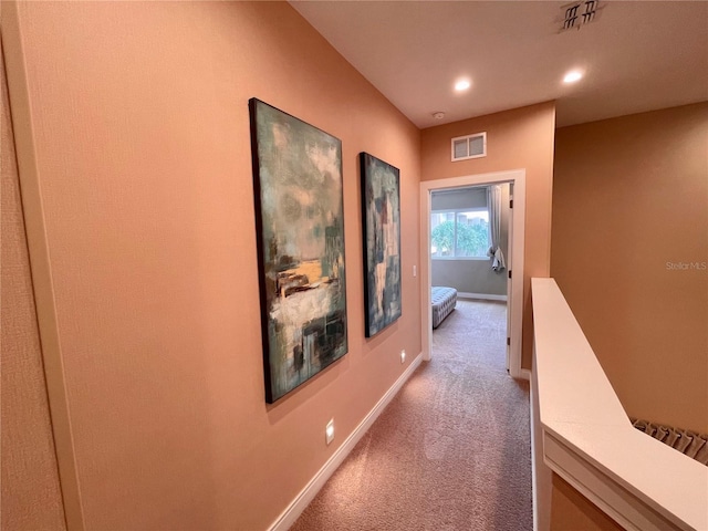 hall featuring baseboards, visible vents, light colored carpet, and recessed lighting