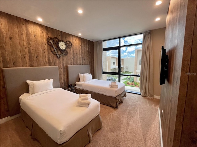 bedroom featuring wooden walls, recessed lighting, light carpet, and baseboards