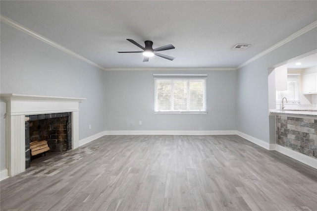 unfurnished living room with visible vents, wood finished floors, a ceiling fan, and crown molding