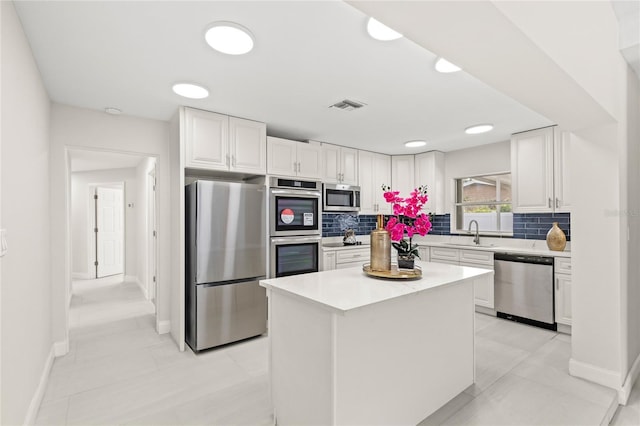 kitchen featuring white cabinetry, appliances with stainless steel finishes, visible vents, and tasteful backsplash