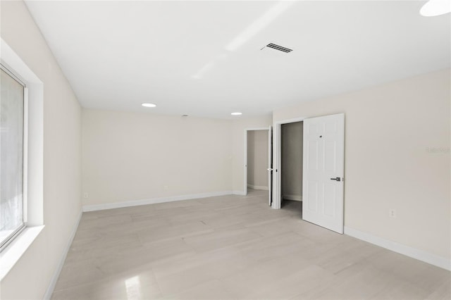 spare room featuring visible vents, recessed lighting, and baseboards