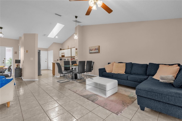 living room with visible vents, a ceiling fan, lofted ceiling with skylight, and light tile patterned flooring