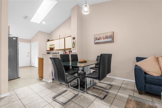 dining area with a skylight, baseboards, high vaulted ceiling, and light tile patterned flooring