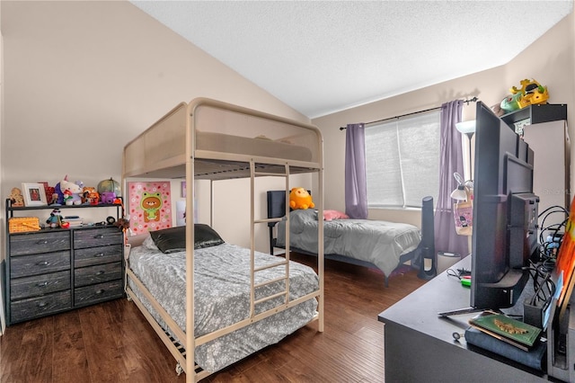 bedroom with a textured ceiling, wood finished floors, and lofted ceiling