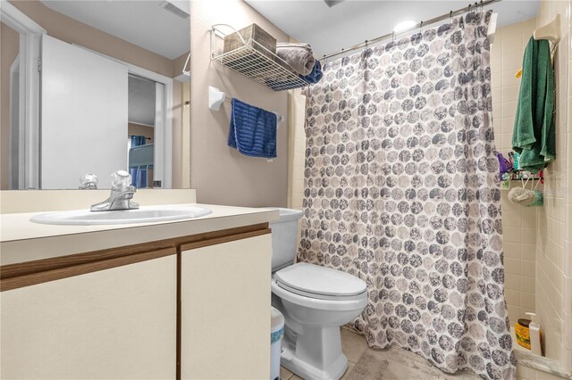 bathroom featuring toilet, a shower with curtain, visible vents, and vanity