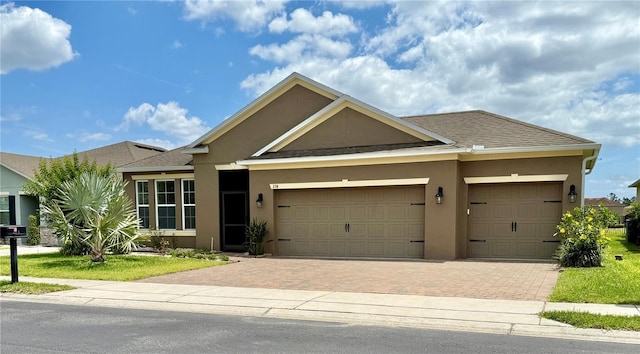 274 Brunswick Dr, Davenport, FL 33837 - single story home with stucco siding, decorative driveway, a garage, and roof with shingles