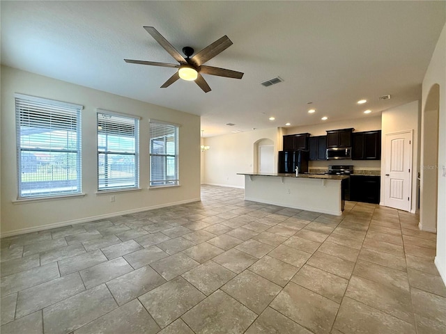 274 Brunswick Dr, Davenport, FL 33837 - kitchen with open floor plan, appliances with stainless steel finishes, ceiling fan, a kitchen bar, and dark cabinets