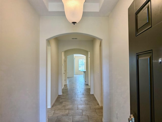 274 Brunswick Dr, Davenport, FL 33837 - corridor featuring baseboards, arched walkways, and a tray ceiling