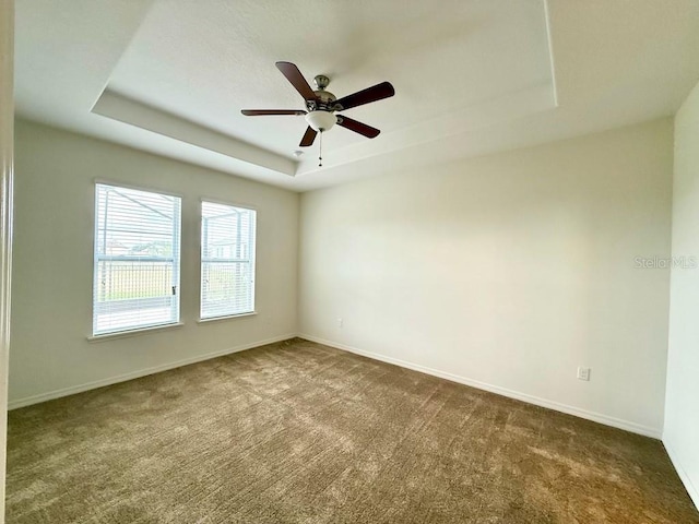 274 Brunswick Dr, Davenport, FL 33837 - spare room featuring a raised ceiling, dark carpet, and baseboards