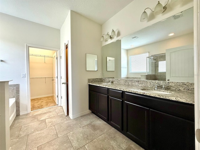 274 Brunswick Dr, Davenport, FL 33837 - full bathroom featuring a stall shower, a walk in closet, baseboards, double vanity, and a garden tub