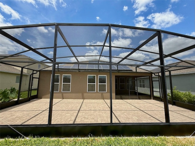 274 Brunswick Dr, Davenport, FL 33837 - rear view of property featuring glass enclosure, a patio area, and stucco siding