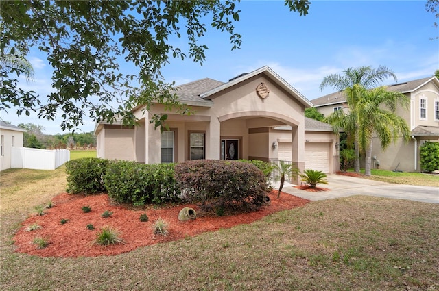 mediterranean / spanish-style house with concrete driveway, an attached garage, a front yard, and stucco siding