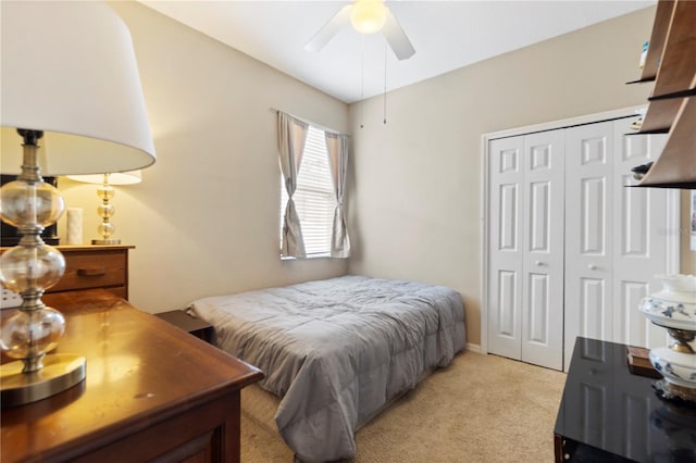 bedroom featuring ceiling fan, light colored carpet, and a closet