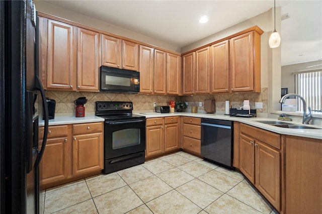 kitchen with a sink, light countertops, decorative backsplash, and black appliances