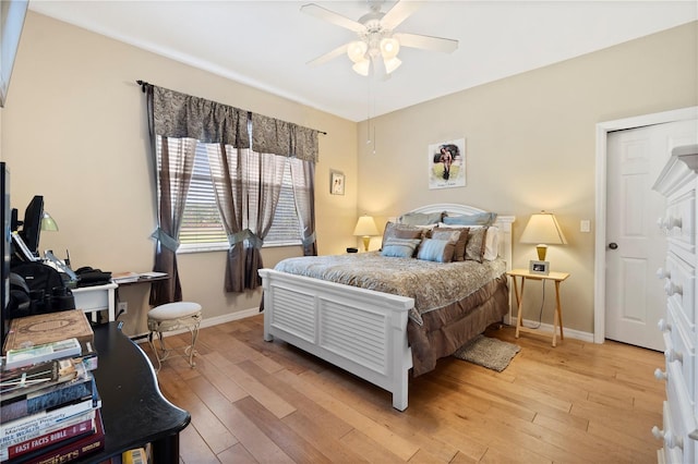 bedroom featuring baseboards, light wood finished floors, and ceiling fan